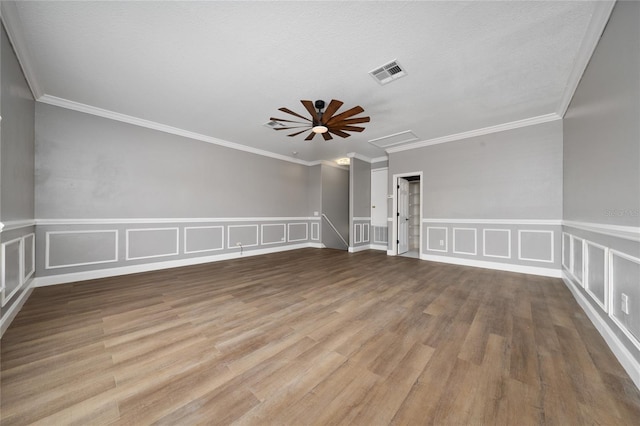 1950 Windward Oaks Ct, Kissimmee, FL 34746 - spare room featuring a decorative wall, ceiling fan, wood finished floors, crown molding, and wainscoting
