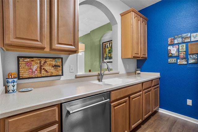 1351 Venezia Ct Unit 201, Davenport, FL 33896 - kitchen featuring stainless steel dishwasher, dark wood finished floors, light countertops, arched walkways, and a textured wall