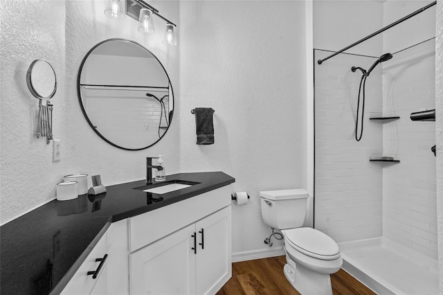 1351 Venezia Ct Unit 201, Davenport, FL 33896 - full bathroom featuring wood finished floors, vanity, a textured wall, and a tile shower
