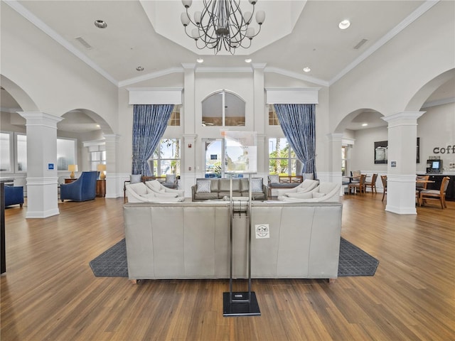 1351 Venezia Ct Unit 201, Davenport, FL 33896 - living area featuring high vaulted ceiling, wood finished floors, a chandelier, ornate columns, and a wainscoted wall