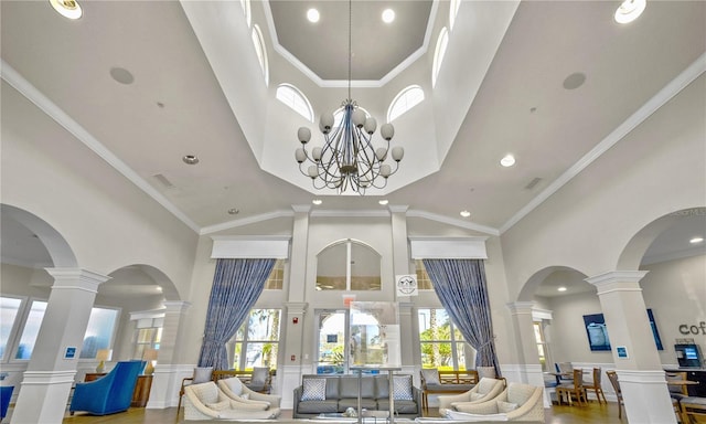 1351 Venezia Ct Unit 201, Davenport, FL 33896 - living area with a high ceiling, decorative columns, a wainscoted wall, a decorative wall, and a chandelier