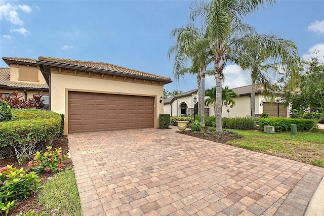 17109 Kenton Ter, Bradenton, FL 34202 - mediterranean / spanish home with stucco siding, decorative driveway, an attached garage, and a tile roof