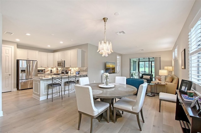 17109 Kenton Ter, Bradenton, FL 34202 - dining area with light wood finished floors, a chandelier, and recessed lighting