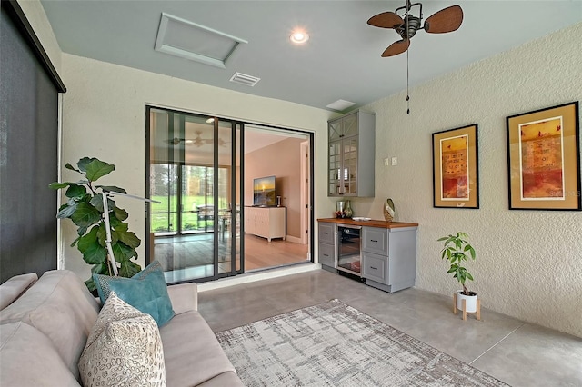 17109 Kenton Ter, Bradenton, FL 34202 - living room featuring wine cooler, attic access, a textured wall, concrete floors, and a ceiling fan