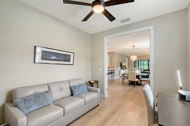 17109 Kenton Ter, Bradenton, FL 34202 - living room with light wood finished floors, a chandelier, and a ceiling fan