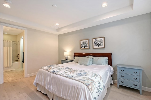 17109 Kenton Ter, Bradenton, FL 34202 - bedroom featuring light wood-type flooring, a tray ceiling, recessed lighting, and ensuite bathroom