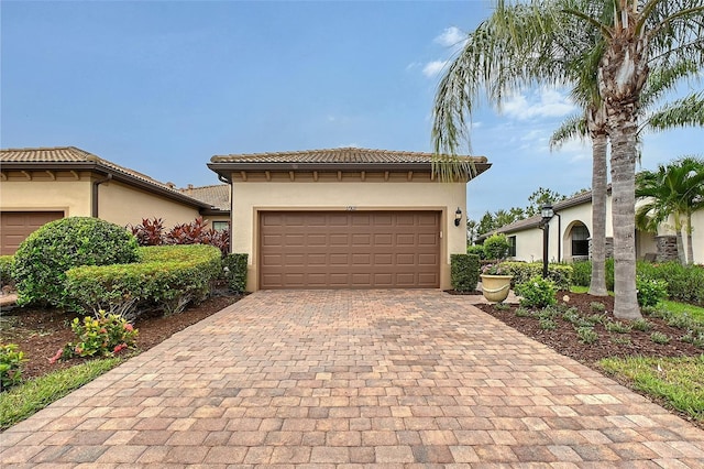 17109 Kenton Ter, Bradenton, FL 34202 - mediterranean / spanish-style house featuring a garage, decorative driveway, stucco siding, and a tiled roof