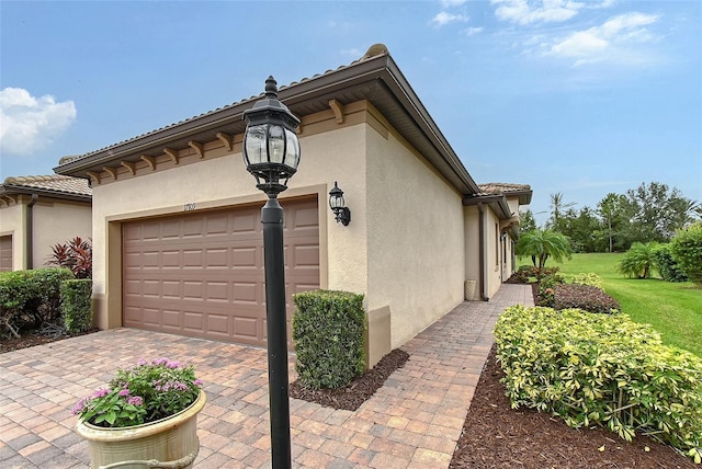 17109 Kenton Ter, Bradenton, FL 34202 - view of property exterior featuring stucco siding, an attached garage, driveway, and a yard