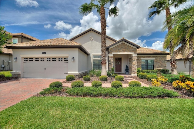 1452 Mickelson Ct, Davenport, FL 33896 - view of front of property featuring stone siding, stucco siding, decorative driveway, an attached garage, and a tile roof