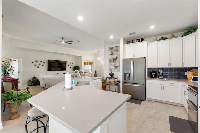 1452 Mickelson Ct, Davenport, FL 33896 - kitchen featuring appliances with stainless steel finishes, light countertops, open floor plan, white cabinets, and recessed lighting