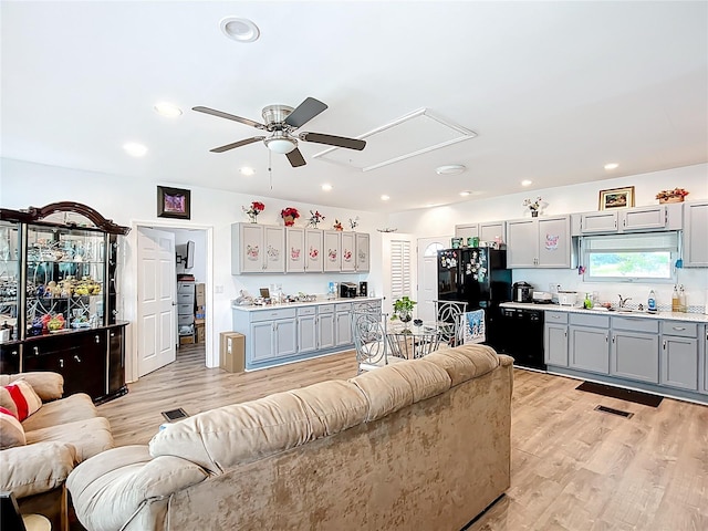living area featuring attic access, a ceiling fan, light wood-style flooring, and recessed lighting