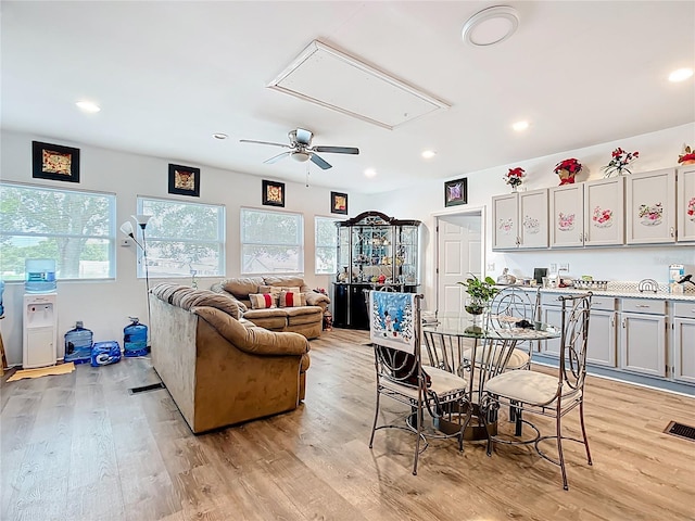 living area featuring attic access, healthy amount of natural light, light wood finished floors, and recessed lighting
