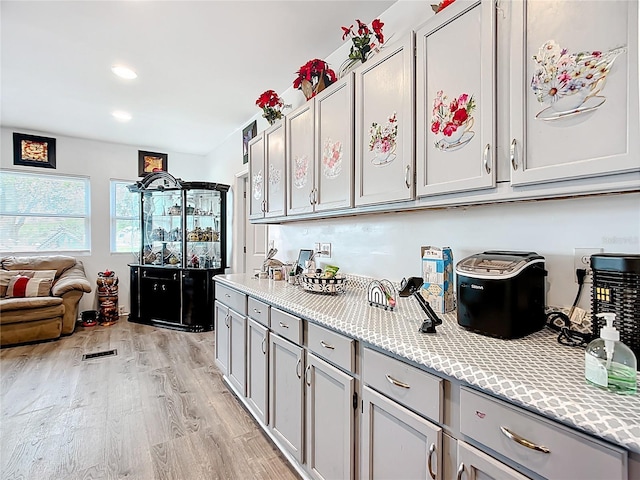 kitchen featuring light wood-style floors, gray cabinets, open floor plan, and recessed lighting