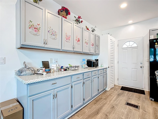 kitchen featuring light wood finished floors, light countertops, recessed lighting, and gray cabinets