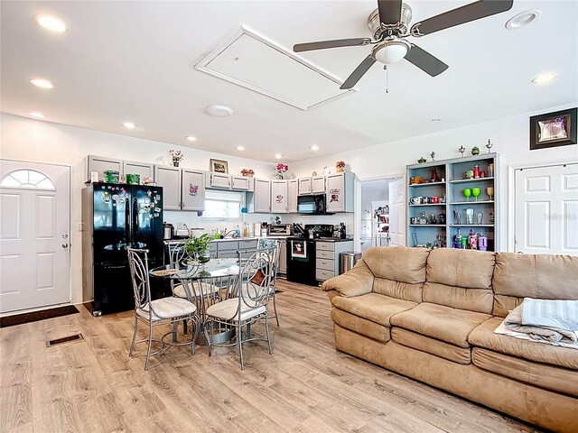 living area featuring attic access, a ceiling fan, light wood-style floors, and recessed lighting