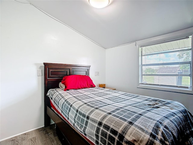 bedroom featuring lofted ceiling and wood finished floors