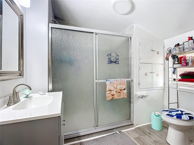 full bathroom featuring wood finished floors, vanity, a shower stall, and lofted ceiling