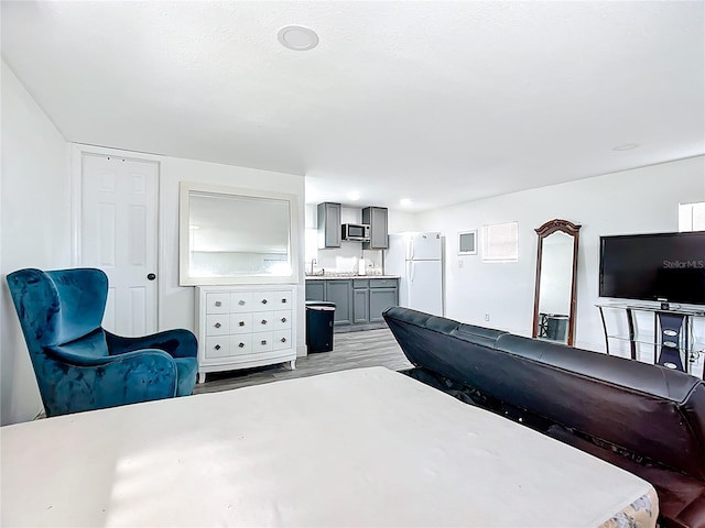 bedroom featuring freestanding refrigerator and light wood-style floors