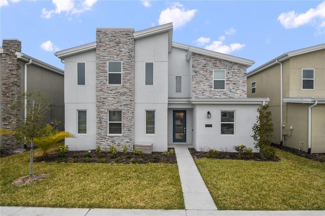 4547 Narrative Ln, Kissimmee, FL 34746 - contemporary home featuring stucco siding, stone siding, and a front lawn