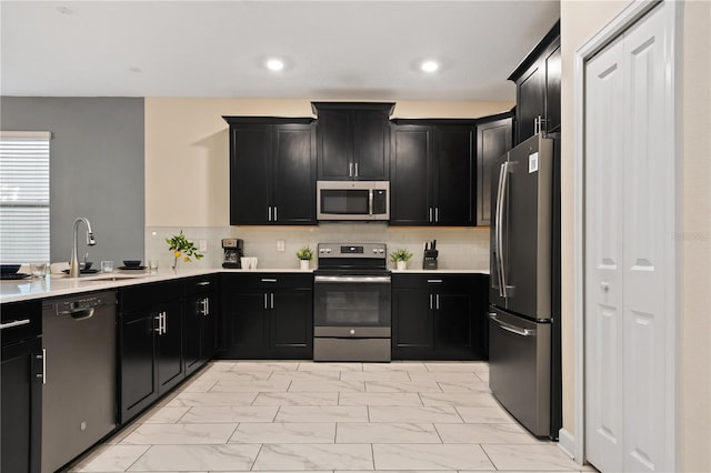 4547 Narrative Ln, Kissimmee, FL 34746 - kitchen featuring stainless steel appliances, dark cabinets, light marble finish flooring, and recessed lighting