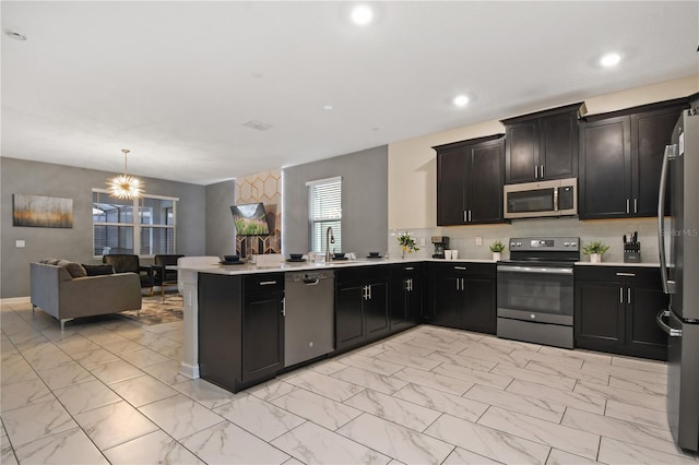 4547 Narrative Ln, Kissimmee, FL 34746 - kitchen with stainless steel appliances, light marble finish flooring, a peninsula, light countertops, and recessed lighting