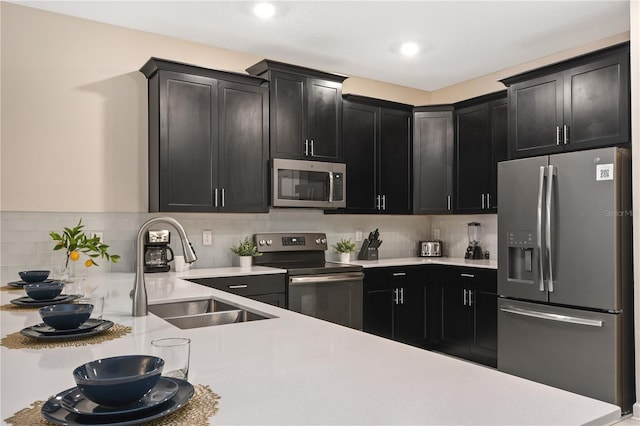 4547 Narrative Ln, Kissimmee, FL 34746 - kitchen with stainless steel appliances, light countertops, backsplash, dark cabinets, and recessed lighting