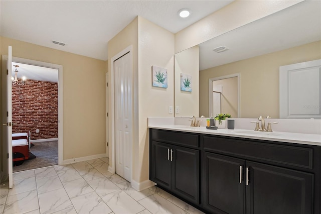 4547 Narrative Ln, Kissimmee, FL 34746 - full bathroom featuring brick wall, double vanity, and marble look tile flooring