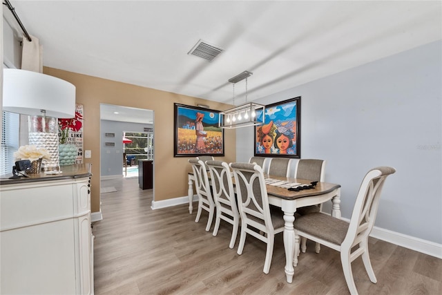 13129 Cog Hill Way, Orlando, FL 32828 - dining room featuring light wood-style floors and a chandelier