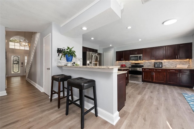 13129 Cog Hill Way, Orlando, FL 32828 - kitchen featuring stainless steel appliances, a breakfast bar area, backsplash, and recessed lighting