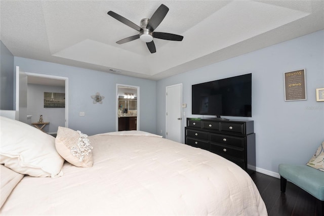 13129 Cog Hill Way, Orlando, FL 32828 - bedroom featuring a raised ceiling, dark wood-type flooring, ensuite bath, and ceiling fan