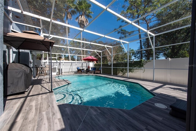 13129 Cog Hill Way, Orlando, FL 32828 - view of swimming pool featuring area for grilling, a fenced backyard, glass enclosure, and a wooden deck