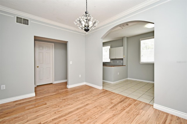 267 Goldenrain Dr Unit 30, Celebration, FL 34747 - spare room with arched walkways, light wood-type flooring, crown molding, and a chandelier