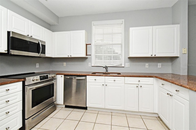267 Goldenrain Dr Unit 30, Celebration, FL 34747 - kitchen featuring stainless steel appliances, light tile patterned floors, and white cabinetry