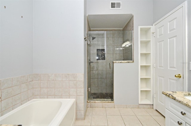 267 Goldenrain Dr Unit 30, Celebration, FL 34747 - bathroom featuring a bath, a shower stall, tile patterned floors, and vanity