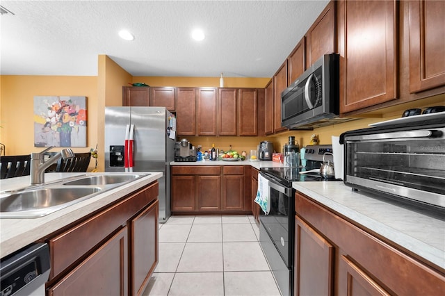 739 Jefferson, Davenport, FL 33837 - kitchen with stainless steel appliances, light countertops, a textured ceiling, light tile patterned floors, and recessed lighting
