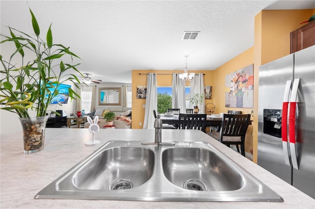 739 Jefferson, Davenport, FL 33837 - kitchen featuring stainless steel refrigerator with ice dispenser, a chandelier, light countertops, decorative light fixtures, and a textured ceiling