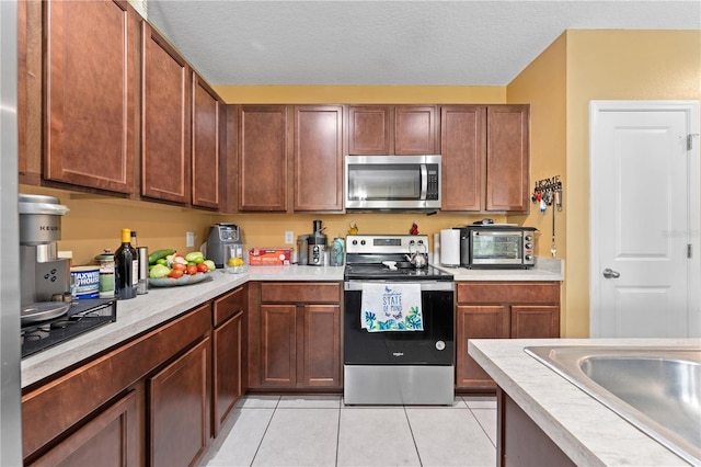 739 Jefferson, Davenport, FL 33837 - kitchen with appliances with stainless steel finishes, light countertops, light tile patterned floors, and a textured ceiling