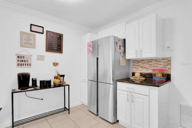 1710 Thor Ave, Apopka, FL 32703 - kitchen with freestanding refrigerator, backsplash, white cabinets, light tile patterned floors, and crown molding