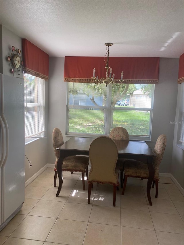 13327 Caspian Ln, Clermont, FL 34711 - dining area featuring a textured ceiling, light tile patterned flooring, and a chandelier