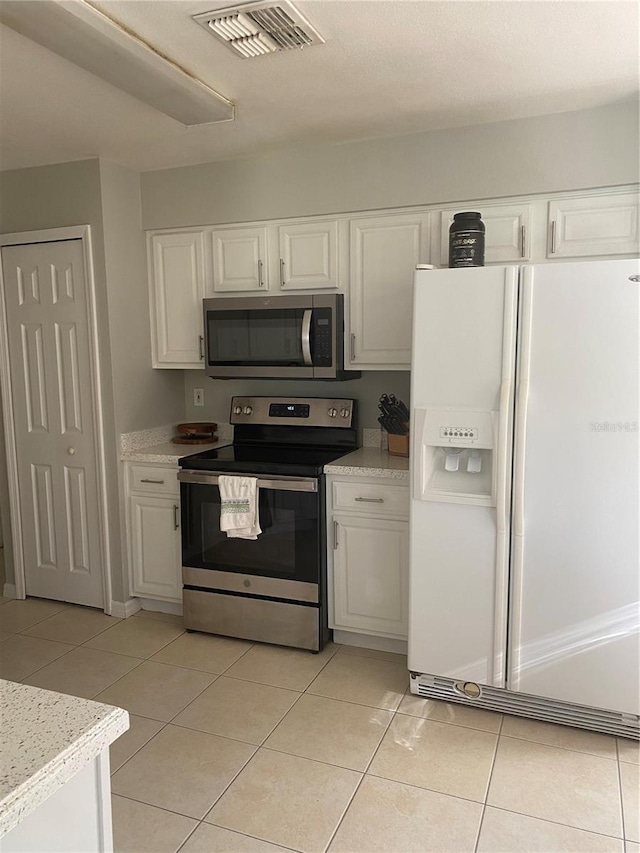 13327 Caspian Ln, Clermont, FL 34711 - kitchen featuring stainless steel appliances, white cabinetry, light countertops, and light tile patterned floors