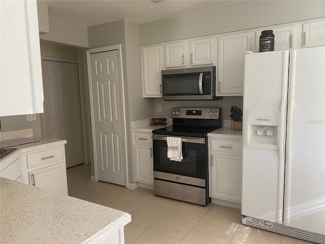 13327 Caspian Ln, Clermont, FL 34711 - kitchen featuring stainless steel appliances, light tile patterned floors, white cabinetry, and light countertops