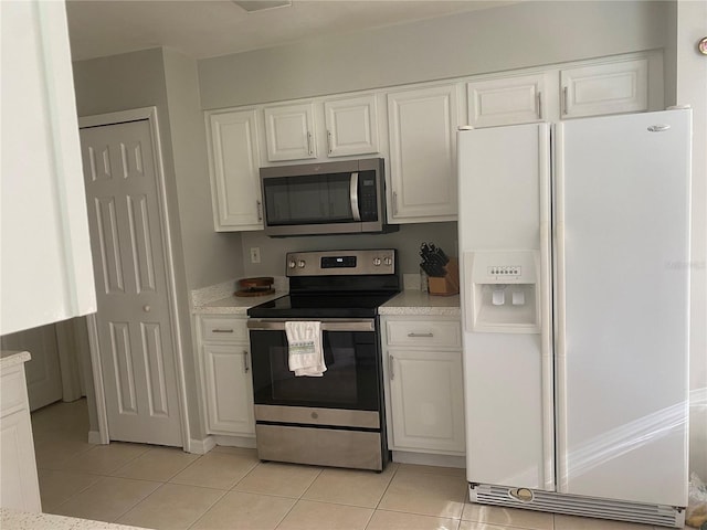 13327 Caspian Ln, Clermont, FL 34711 - kitchen with appliances with stainless steel finishes, light tile patterned flooring, white cabinetry, and light countertops
