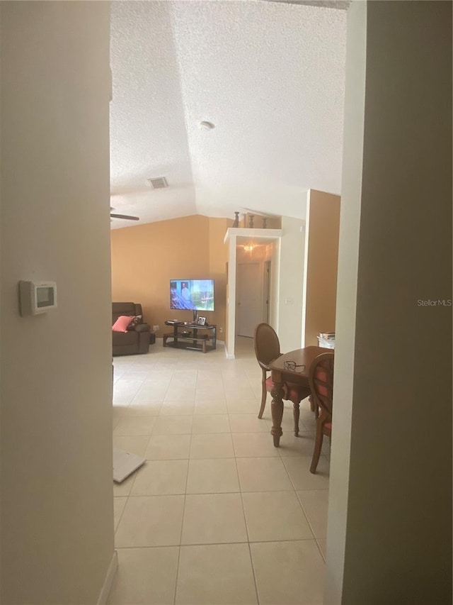 13327 Caspian Ln, Clermont, FL 34711 - corridor featuring vaulted ceiling, light tile patterned floors, and a textured ceiling