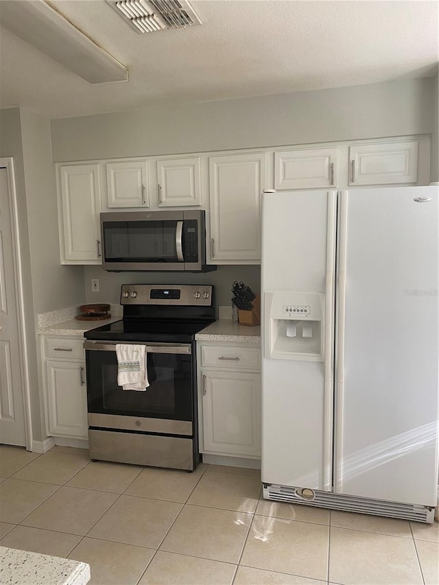 13327 Caspian Ln, Clermont, FL 34711 - kitchen with appliances with stainless steel finishes, white cabinets, light countertops, and light tile patterned flooring