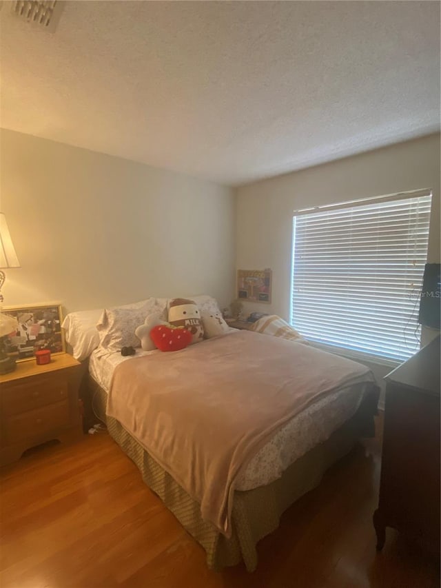 13327 Caspian Ln, Clermont, FL 34711 - bedroom with light wood-type flooring and a textured ceiling