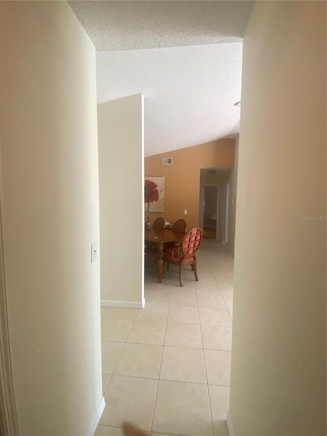 13327 Caspian Ln, Clermont, FL 34711 - hallway featuring lofted ceiling, light tile patterned floors, and a textured ceiling