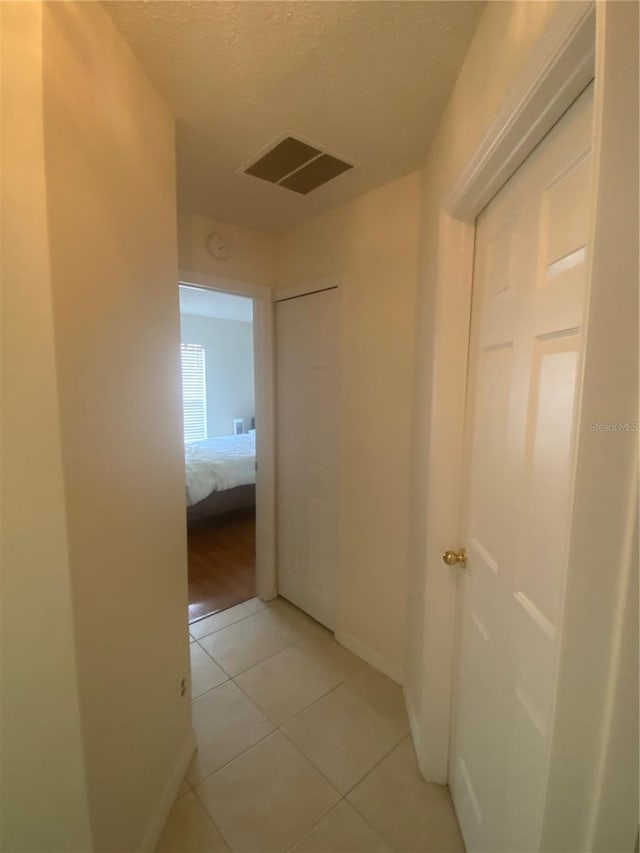 13327 Caspian Ln, Clermont, FL 34711 - hall featuring light tile patterned flooring and a textured ceiling