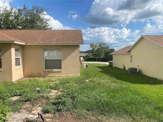 13327 Caspian Ln, Clermont, FL 34711 - view of home's exterior with a lawn, stucco siding, and a shingled roof