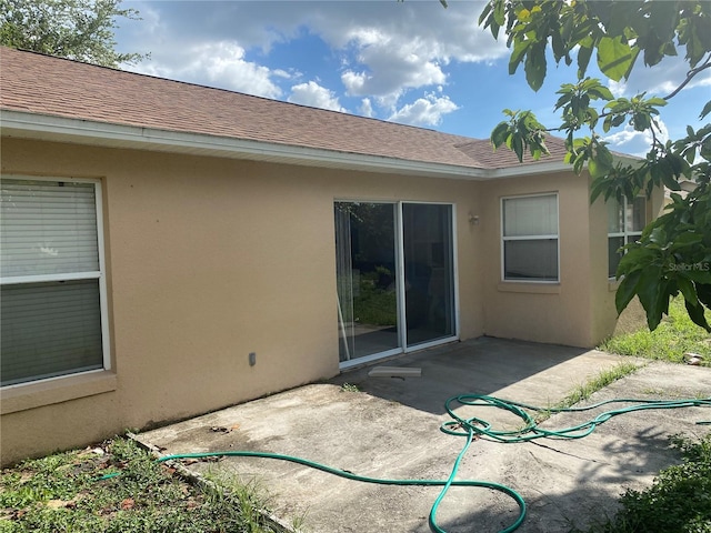 13327 Caspian Ln, Clermont, FL 34711 - back of property with stucco siding, a patio, and a shingled roof