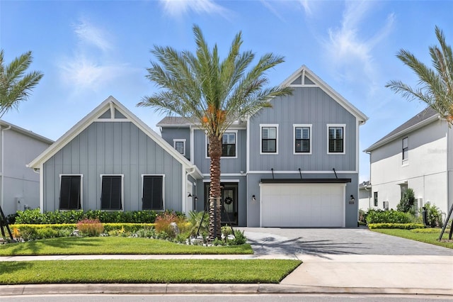 9352 Santorini Dr, Orlando, FL 32827 - view of front facade featuring board and batten siding, concrete driveway, an attached garage, and a front yard